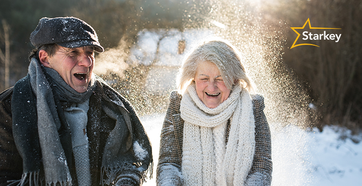 Image of a joyful senior couple walking outside in the snow